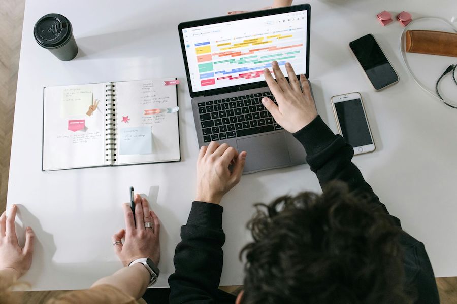 A group of people collaborating on a laptop at a table, focused on their work and sharing ideas.